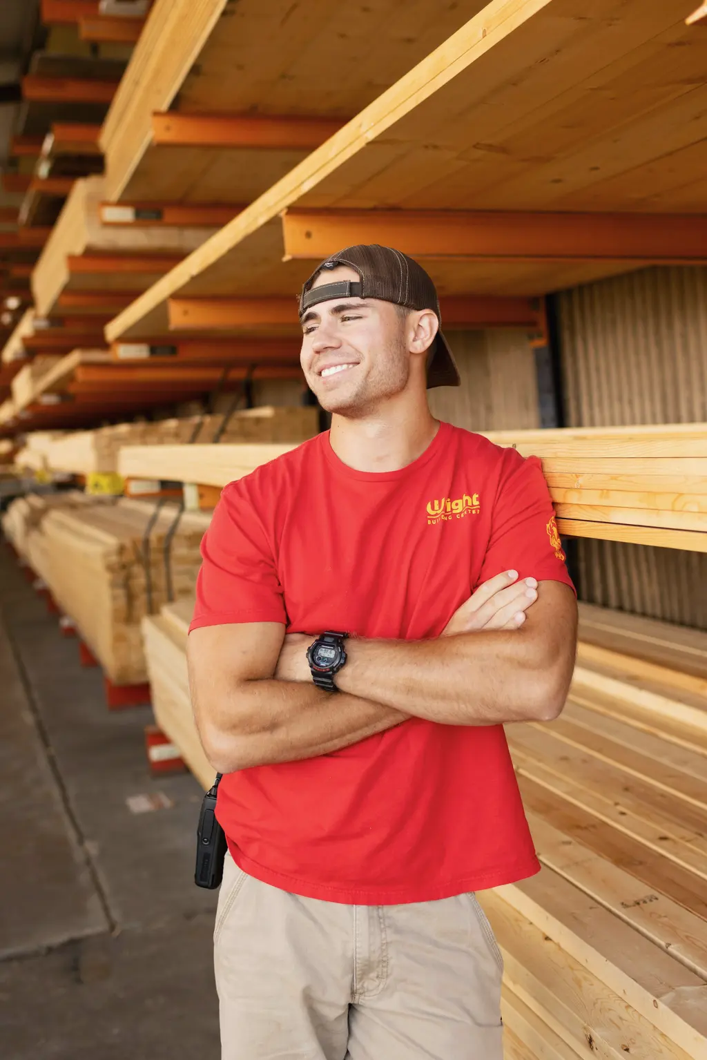 A smiling worker in a lumberyard